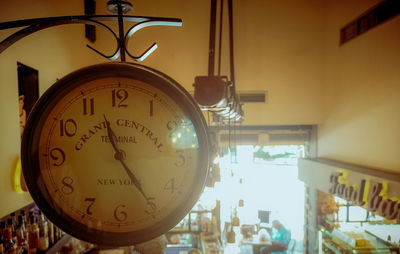 Close-up of clock hanging on glass