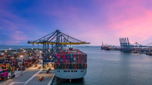 Container ship in seaport at night, global business logistic import export freight shipping