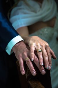 Midsection of bride and groom wearing rings