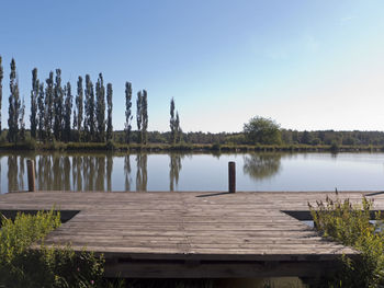 Wooden pier on lake against sky