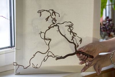 Midsection of person holding paper against window