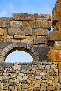 Low angle view of stone wall against sky