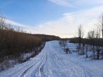 Snow covered road against sky during winter