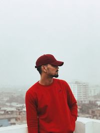 Man standing in city against sky