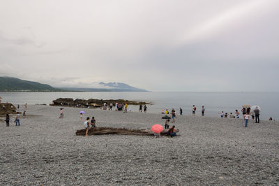 People on beach against sky