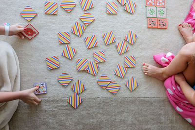 Overhead view of kids playing card game sitting on a rug
