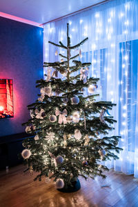 Illuminated christmas tree on floor at home