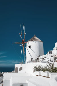 Wind turbines on building against blue sky