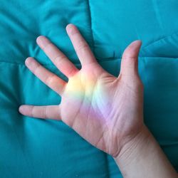 Close-up of human hand with spectrum on duvet