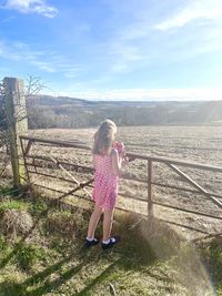 Rear view of woman on landscape against sky