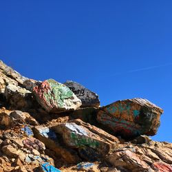 Low angle view of rock formation against clear blue sky