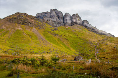 Walking track up to the old man of storr rock formation. isle of skye, scotland. gate in foreground.