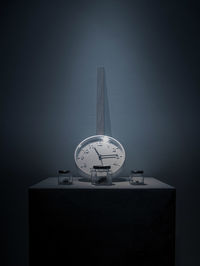 Clock tower on table against wall
