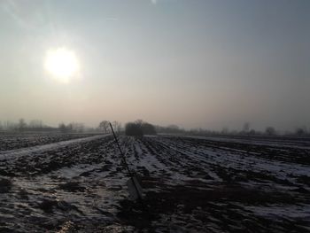 Scenic view of snowy field against sky during winter