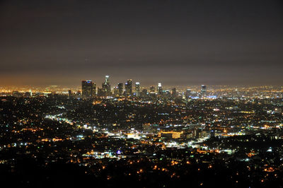 Illuminated cityscape against sky at night