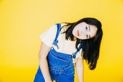 Portrait of girl against yellow background