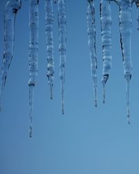 Close-up of icicles against clear blue sky