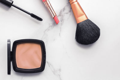 High angle view of make-up brushes against white background