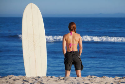 Rear view of shirtless boy standing on beach