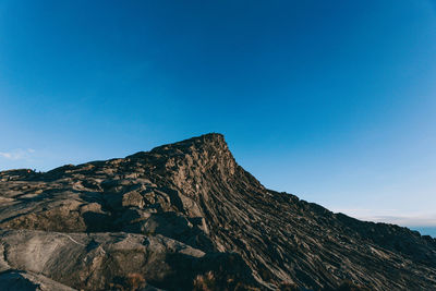 Scenic view of rocky mountains against clear blue sky