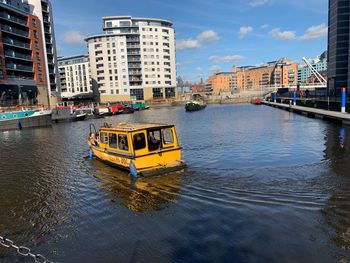 River by buildings in city against sky