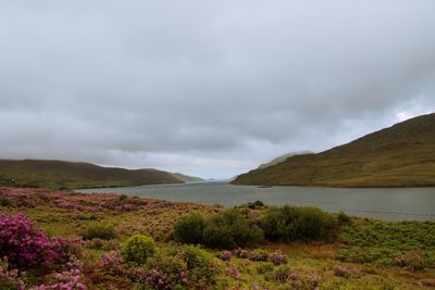 Scenic view of mountains and lake against cloudy sky