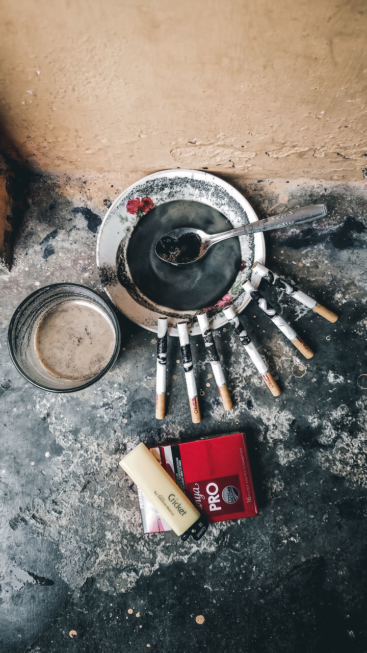 HIGH ANGLE VIEW OF CIGARETTE IN CONTAINER ON FLOOR