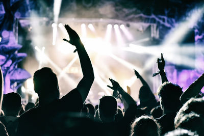 Crowd against illuminated stage during popular music concert at night