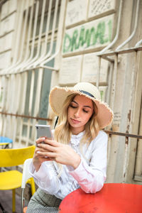 Young woman using mobile phone in laptop