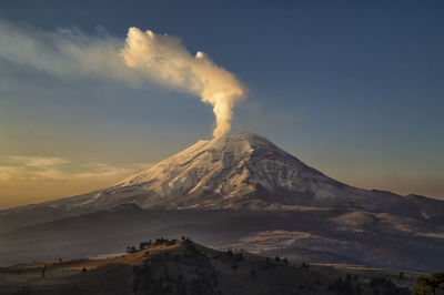 Smoke emitting from volcanic mountain against sky