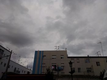 Low angle view of buildings against cloudy sky