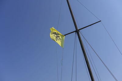 Low angle view of flags against blue sky