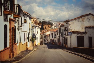 Road amidst buildings against sky