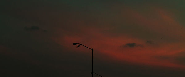 Low angle view of street light against dramatic sky