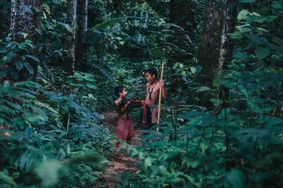 Rear view of people enjoying in forest