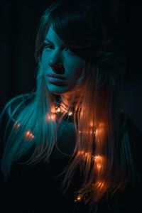 Portrait of beautiful woman wearing hat against black background