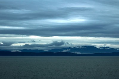 Scenic view of sea and mountains against sky