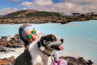 Girl and dog sitting by lagoon