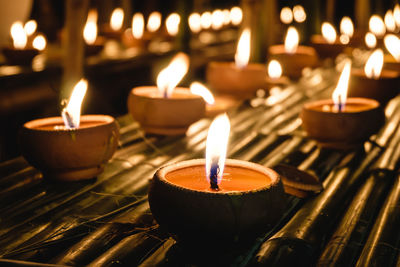 Close-up of lit candles in temple