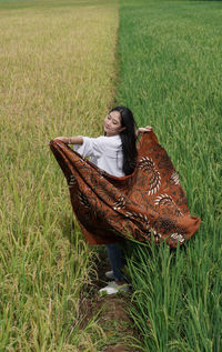 High angle view of woman sitting on grassy field