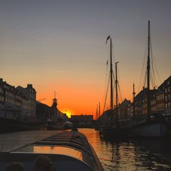 Boats in river at sunset