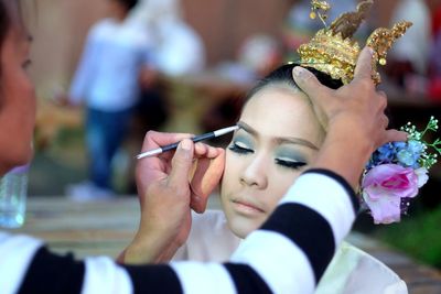 Artist applying make-up on young woman