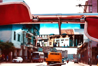 Reflection of buildings in rear view mirror of car 