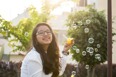 Portrait of a smiling young woman with bubbles