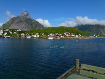 Scenic view of sea by buildings against blue sky