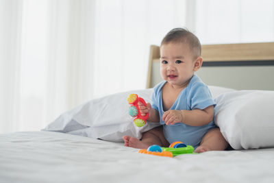 Cute boy lying down on bed at home