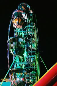 Low angle view of illuminated ferris wheel against sky at night