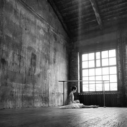 Side view of ballet dancer sitting on floor