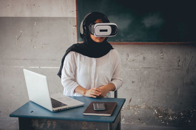 Female teacher using virtual reality simulator in classroom