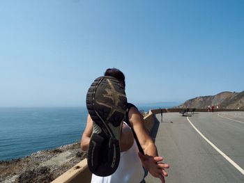 Rear view of man against sea against clear sky